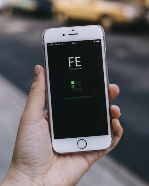 A hand holding a smartphone on a street, ready to take a photo